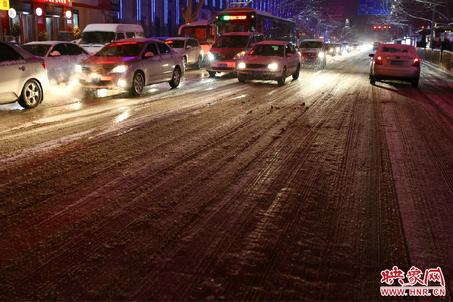 夜晚的雪路給出行的人們增加了困難。