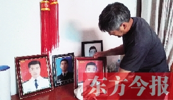 沉浸在悲痛之中的魯有海，擦拭著孩子的遺照