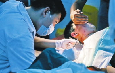 孩子身上有7道傷痕，其中兩道需要縫合，其他的均為擦傷，醫(yī)生正對他施治。