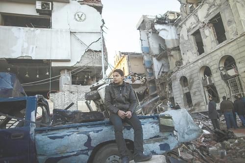 埃及曼蘇拉市警察局24日遭汽車(chē)炸彈襲擊，被疑是穆兄會(huì)的報(bào)復(fù)。圖為一名男子在被炸毀的警察局前。