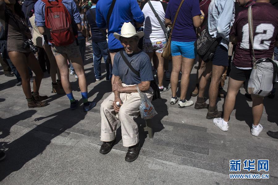 一名男子坐在參加不穿褲子搭地鐵的人群邊小憩。