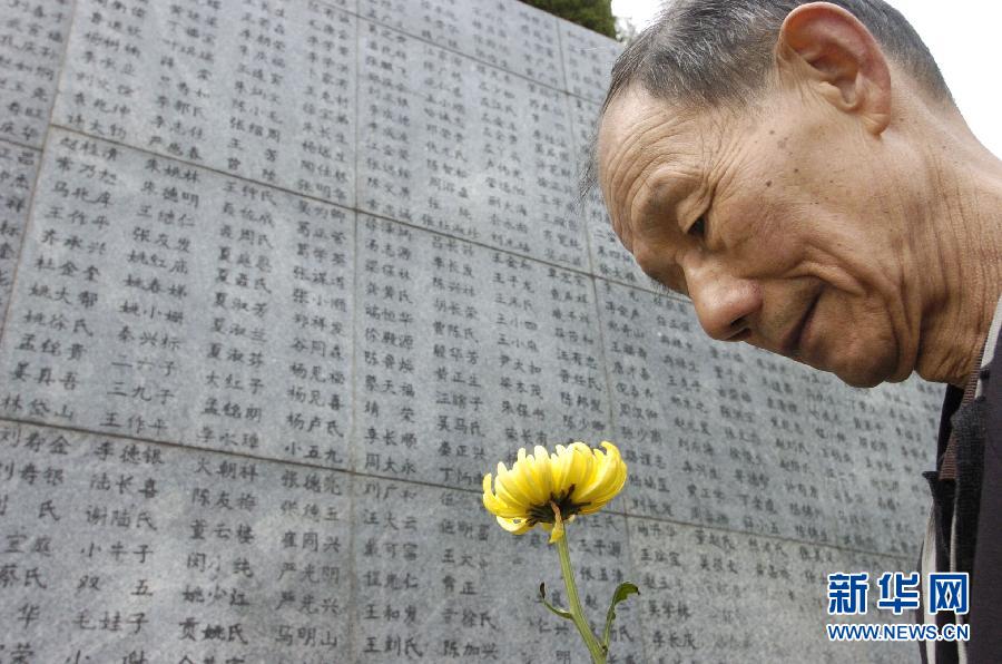 2006年4月5日，74歲的南京大屠殺幸存者佘子清手捧鮮花，祭奠被日軍殺害的母親。