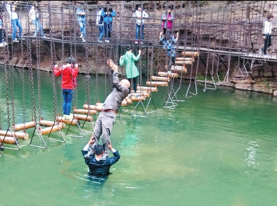 中年男游客正踩著景區(qū)安全員郭小明的肩膀過河。網(wǎng)友“@我的小名叫張孩”供圖