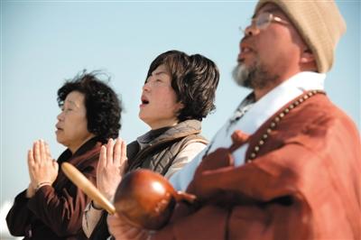 23日，一名僧侶引領(lǐng)人們?yōu)樗勒咂矶\。