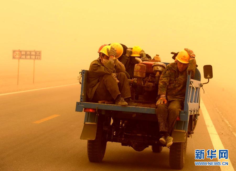 4月23日，一輛拉載公路施工人員的三輪車在沙塵暴中行駛在酒泉市瓜州縣城郊的公路上。