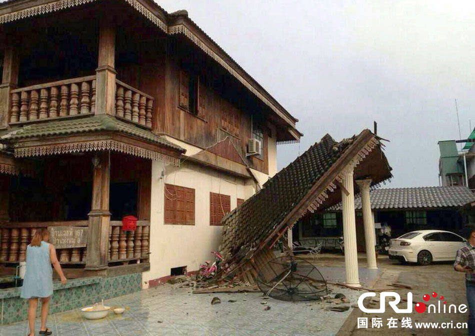 當(dāng)?shù)貢r間2014年5月5日，泰國清萊，一名婦女看著受損的房屋。 圖片來源：東方IC