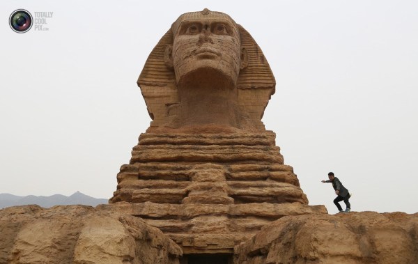 石家莊郊外，一名男子與山寨版獅身人面像合影留念。