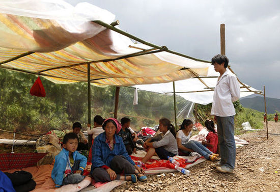 暴雨馬上來臨，村民們在簡易帳篷下躲雨。澎湃新聞 程藝輝 圖