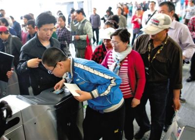 去年5月5日，14號線園博園站，乘客刷卡出地鐵。北京公交地鐵將實行計程票制，多乘坐多付費。