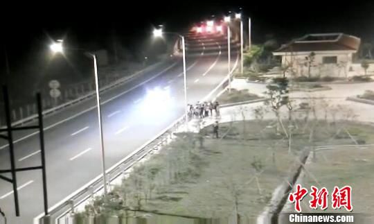 看到車輛經(jīng)過，孩子們便急忙跑到一旁的花圃上?！【焦﹫D　攝