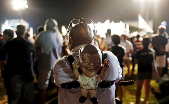 9月4日，新加坡，執(zhí)政黨的一場集會上，一名支持者背著一個李光耀的人偶。