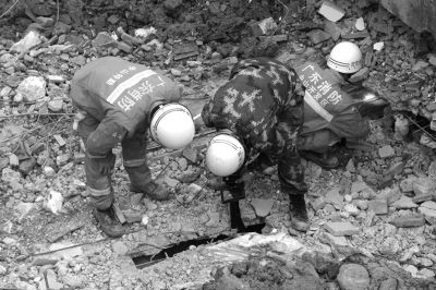 搜救人員正在用探視儀器觀看被掩埋層的情況。