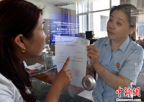 資料圖：2015年5月4日，河北石家莊市橋西區(qū)人民法院立案庭庭長(zhǎng)齊燕正在為立案人辦理相關(guān)手續(xù)，完成整個(gè)過(guò)程只用了5分鐘。當(dāng)日是立案登記制改革首個(gè)工作日，該院共立案36件，立案率達(dá)到90%。中新社發(fā) 翟羽佳 攝