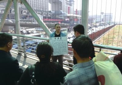 韓先生在北京西站天橋上籌錢。京華時(shí)報(bào)記者陶冉攝