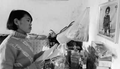 錢仁鳳站在母親遺像前。未能見母親最后一面是她的一大遺憾。