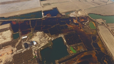 4月19日，廊坊市大城縣南趙扶鎮(zhèn)，津保路以北約八九百米處，一個巨大的污水坑中，水體呈現(xiàn)紅褐色。 新京報記者 尹亞飛 攝