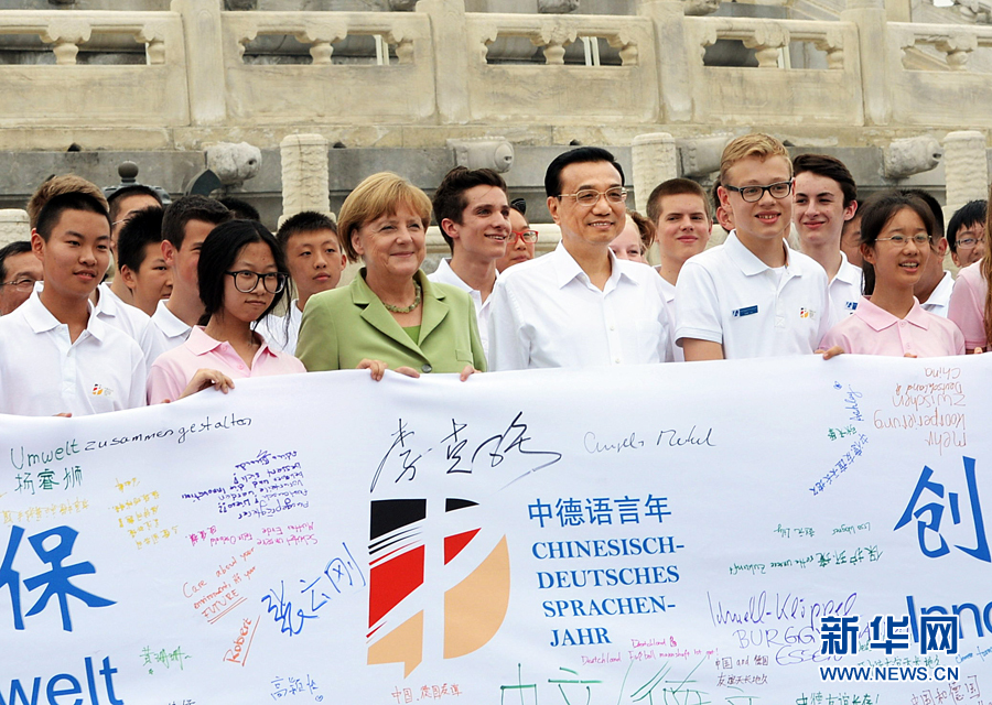 李克強(qiáng)同默克爾與青少年在天壇祈年殿前合影留念。