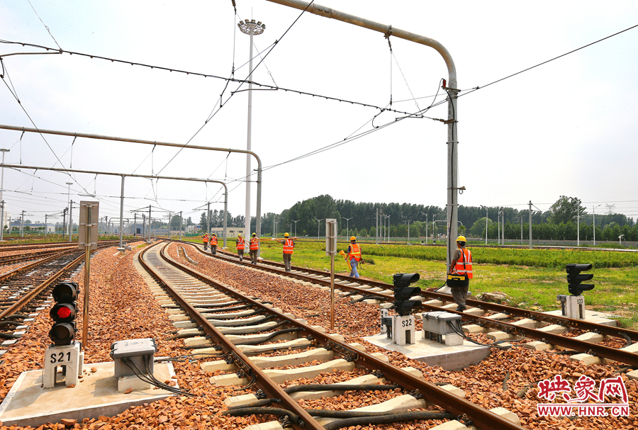 在太陽的直射下，檢修工人扛著沉重的設(shè)備向施工地點(diǎn)出發(fā)