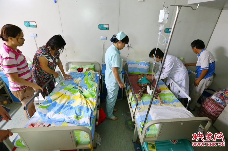 手術(shù)前，畫面右側(cè)的大龍正在接受醫(yī)生的檢查，左側(cè)的小龍還在熟睡。