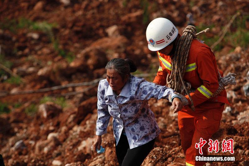 一位消防戰(zhàn)士將一位失去親人的老人扶離滑坡點(diǎn)。