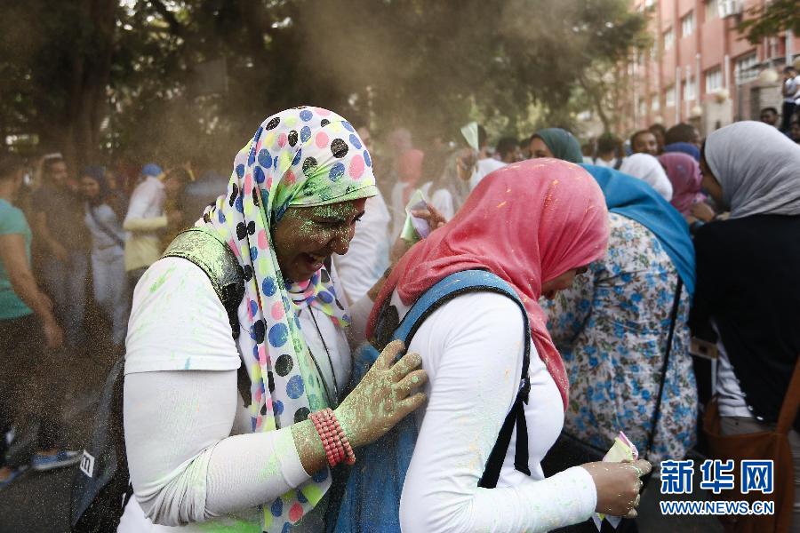 10月16日，在埃及首都開羅，兩名女青年在“彩色跑”活動(dòng)中躲避人們拋撒的彩色粉末。
