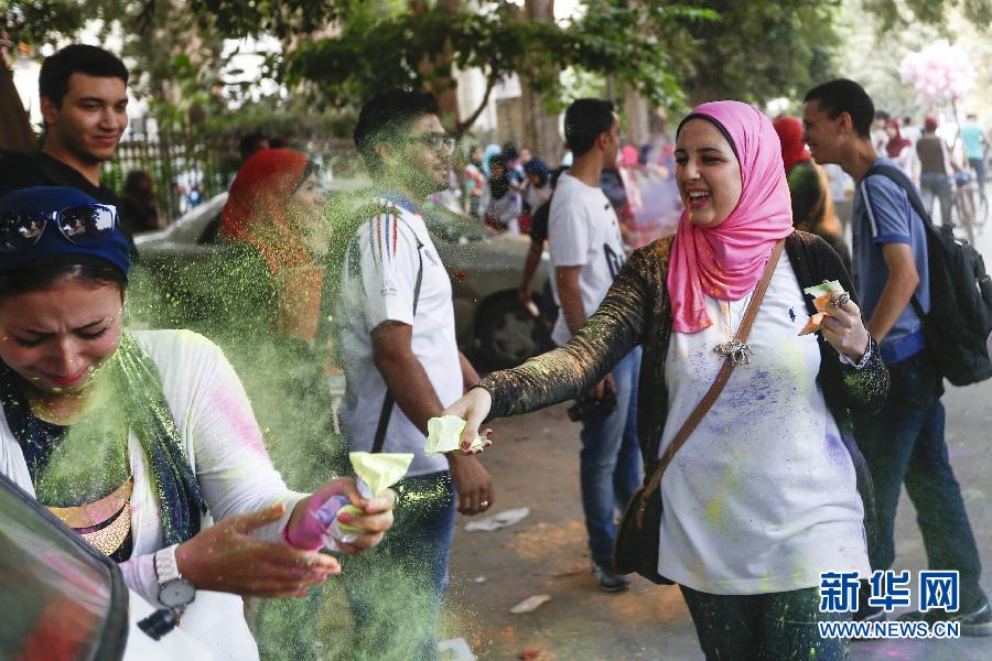 10月16日，在埃及首都開羅，一名女青年在“彩色跑”活動(dòng)中拋撒彩色粉末。