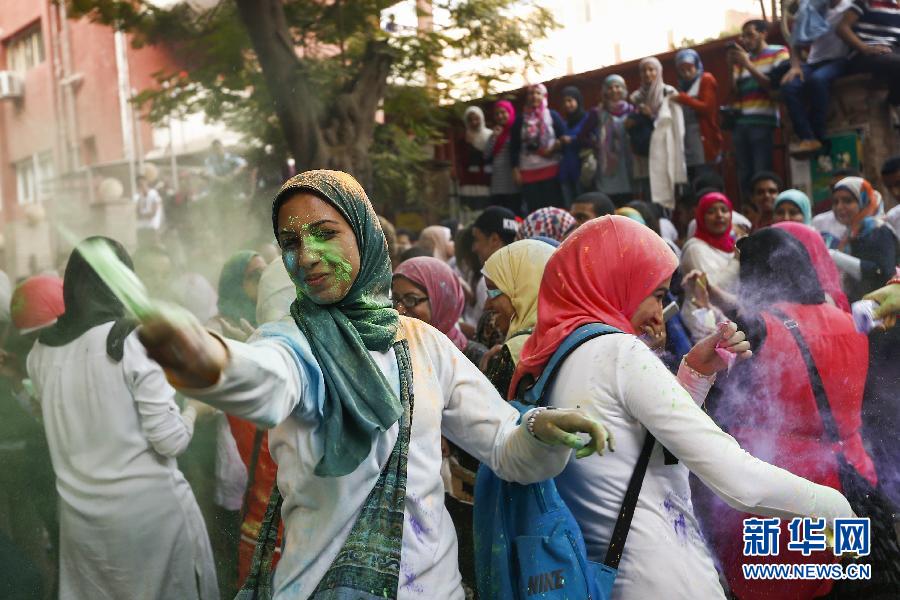 10月16日，在埃及首都開羅，一名女青年在“彩色跑”活動(dòng)中拋撒彩色粉末。