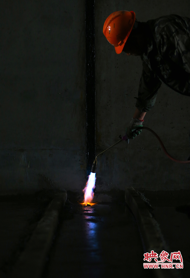 工人師傅用噴槍烘干地面，便于做防水處理