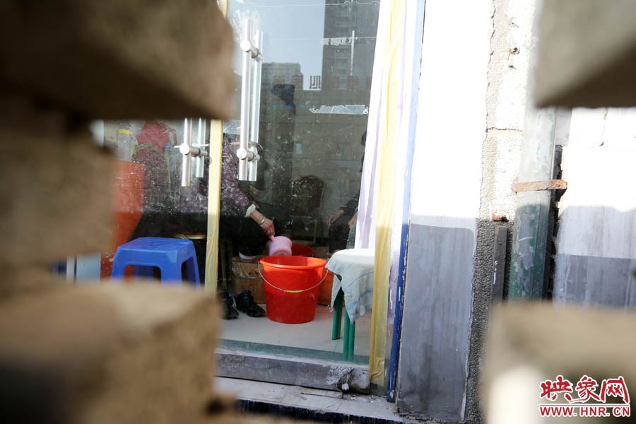 墻內(nèi)一家店面正常營(yíng)業(yè)。