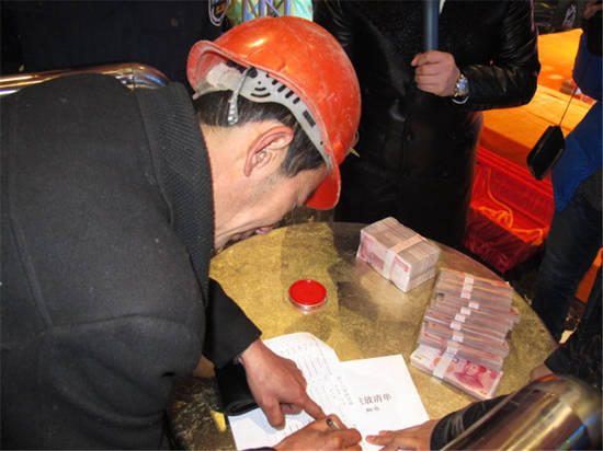 農(nóng)民工在現(xiàn)場(chǎng)領(lǐng)取工資。