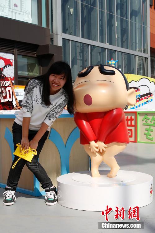 4月22日，游客與蠟筆小新合影。“蠟筆小新25周年紀(jì)念特展”日前在北京開展，吸引了不少市民游客。