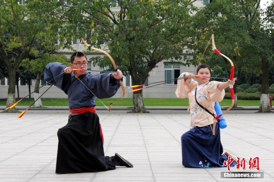 圖為課余練習(xí)射箭的“神雕俠侶”胡雅潔和胡默齋。