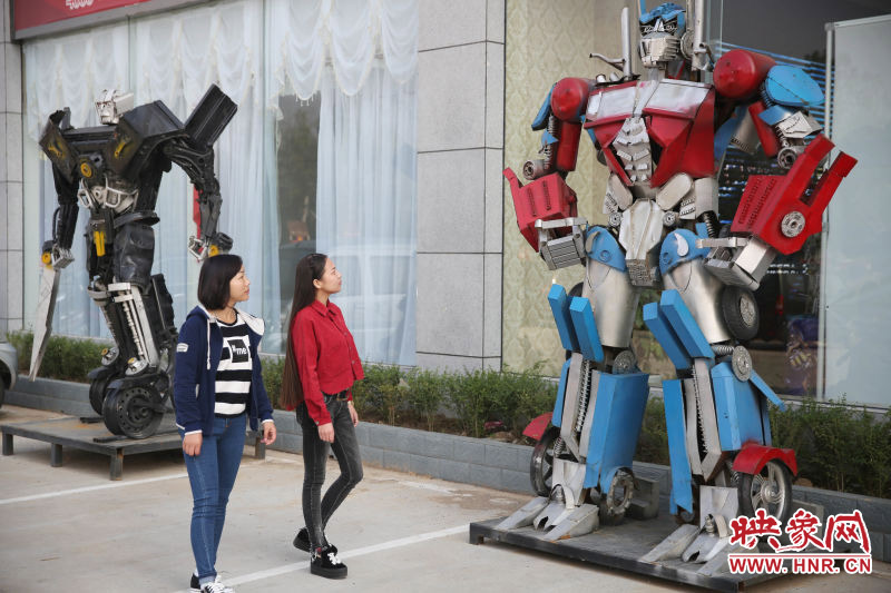 10月14日，市民在參觀河南省平頂山市寶豐縣一家企業(yè)門前的“變形金剛”。