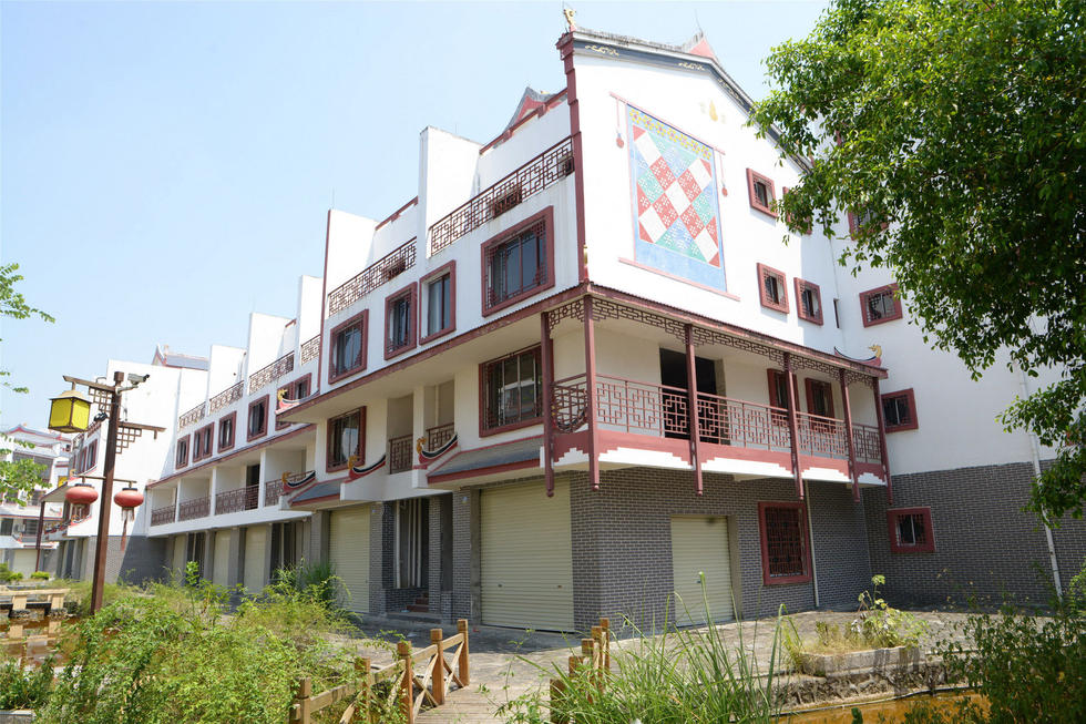 2016年7月26日，村民在廣西來賓市忻城縣隆達山水福城荒廢別墅間放牛。