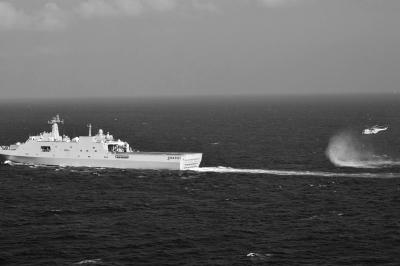 11日，抵達(dá)馬航飛機失聯(lián)海區(qū)的海軍井岡山艦與艦載直升機協(xié)同展開立體搜救行動。新華社發(fā)