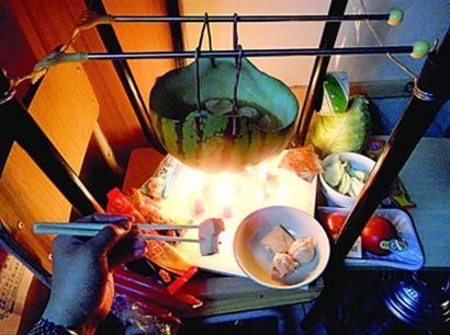 兩張椅子被面對面疊在一起，穿了兩根線的西瓜皮就懸空在椅腳中間，下面有蠟燭加熱，這就是西瓜火鍋。