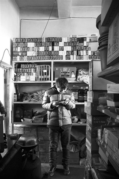 1月21日，周瑋在自家的超市里玩計算器。