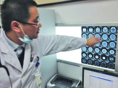 醫(yī)生在查看男孩的腦部CT片。薛馬義 攝