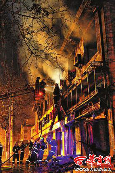 昨日22時(shí)10分，西安市豐慶路南小巷南口，消防官兵架梯子登上二樓施救 本組圖片由本報(bào)記者 閆文青 攝