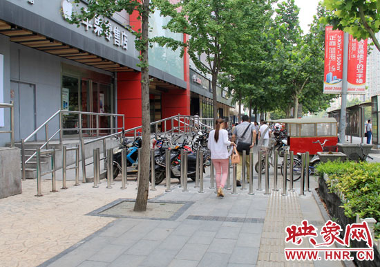 圖中道路左側(cè)的無(wú)障礙通道被鋼管隔離,右側(cè)的盲道也被侵占。