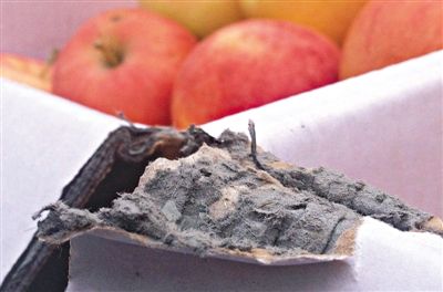 8月29日，新發(fā)地市場，一箱用“加重紙箱”包裝的蘋果正待售，紙箱夾層內(nèi)灰黑色的增重填充物清晰可見