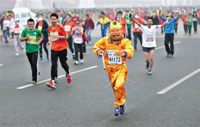 長安街，一名打扮成孫悟空的參賽者在北馬隊(duì)伍里飛奔。 本版攝影/新京報(bào)記者 吳江 李飛 王嘉寧 吳江