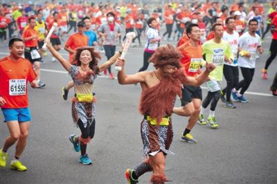 “原始人”打扮的參賽者向觀眾揮手。