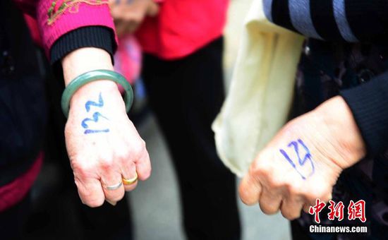 圖為10月28日，在江西九江市一家羊絨皮草服裝服飾博覽會(huì)現(xiàn)場，老人們正在頂著寒風(fēng)排隊(duì)等待領(lǐng)取10元代金劵。