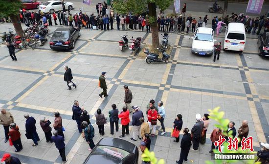 圖為10月28日，在江西九江市一家羊絨皮草服裝服飾博覽會(huì)現(xiàn)場，老人們正在頂著寒風(fēng)排隊(duì)等待領(lǐng)取10元代金劵。