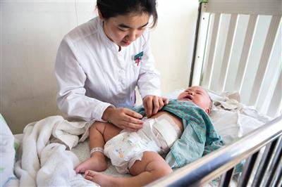 昨日，北京兒童醫(yī)院，護(hù)士為即將出院的被扎鋼針女嬰檢查傷口恢復(fù)情況。記者 高瑋 攝