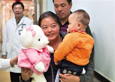 昨日上午，被扎針女嬰的母親抱著孩子和醫(yī)護(hù)人員送的玩偶準(zhǔn)備出院，院方稱孩子術(shù)后恢復(fù)良好。記者 高瑋 攝