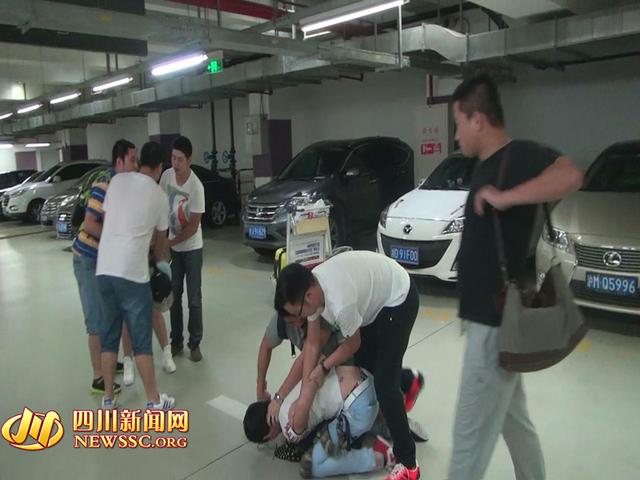 辦案人員在機(jī)場(chǎng)停車場(chǎng)抓獲胡某及其女友（警方視頻截圖）。