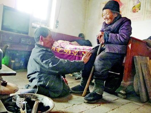 52歲的劉蘭山每天靠爬行照顧90歲的老母親。孫國(guó)祥 攝