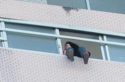 28樓的窗臺(tái)上坐著一名女子，其兩條腿耷拉在室外，不停地?cái)[動(dòng)。